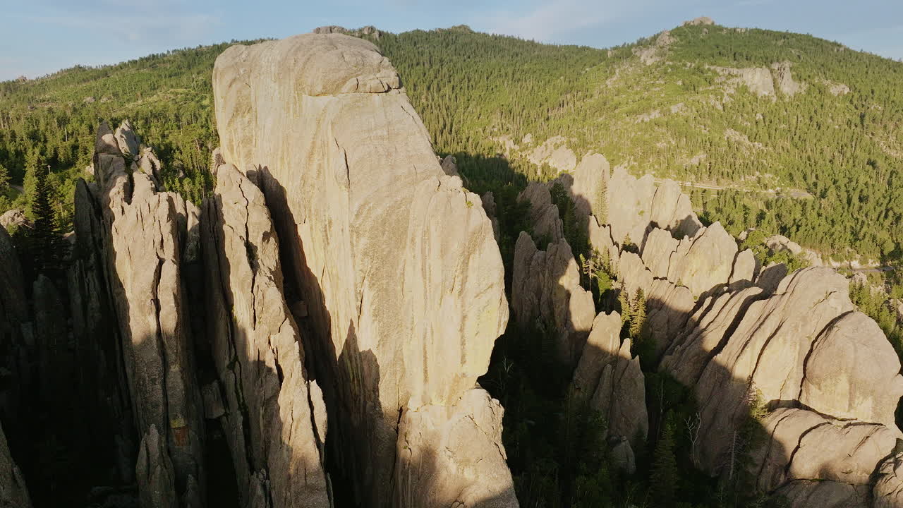 Aerial shot flying over vast, rugged canyons and towering rock spires in the American West.