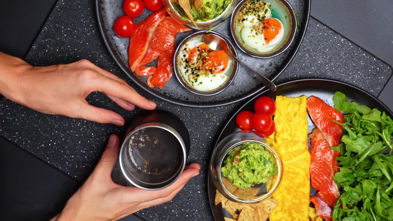 Piatto colazione salutare con guacamole. Piatto colazione con frittata, salmone, rucola e guacamole