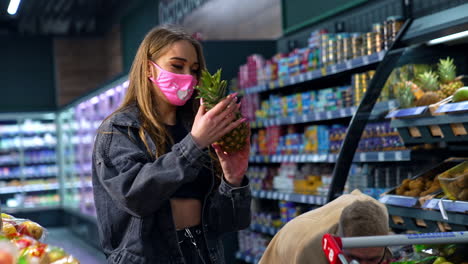 couple shopping for produce in a grocery store during a pandemic