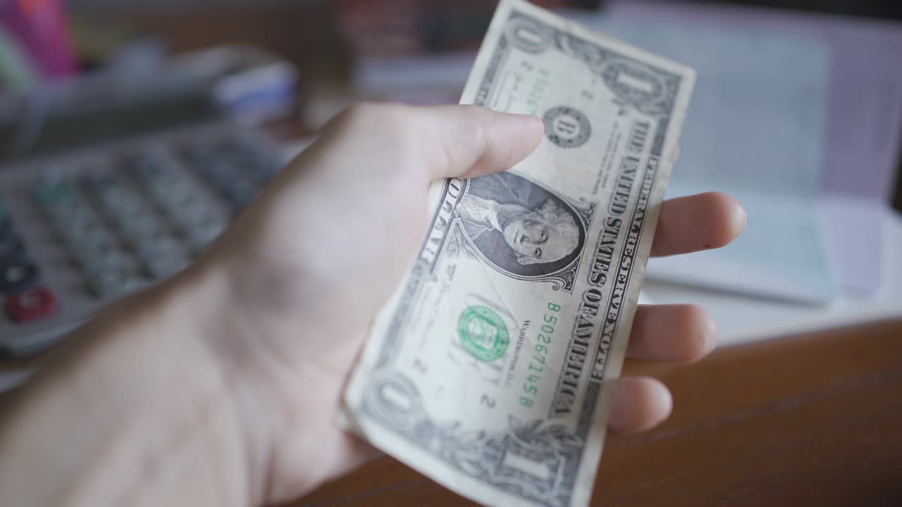 aplastando un billete de un dólar con la mano. concepto de pobreza.