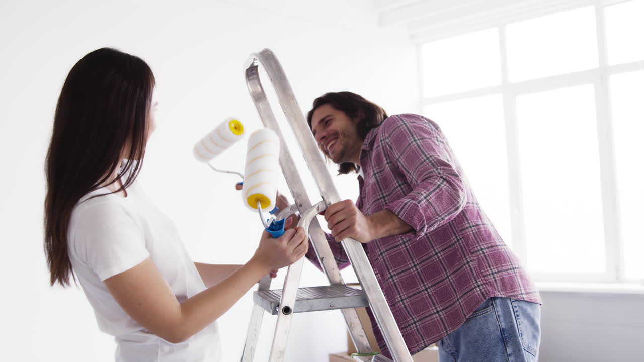 pareja pintando una habitación juntos