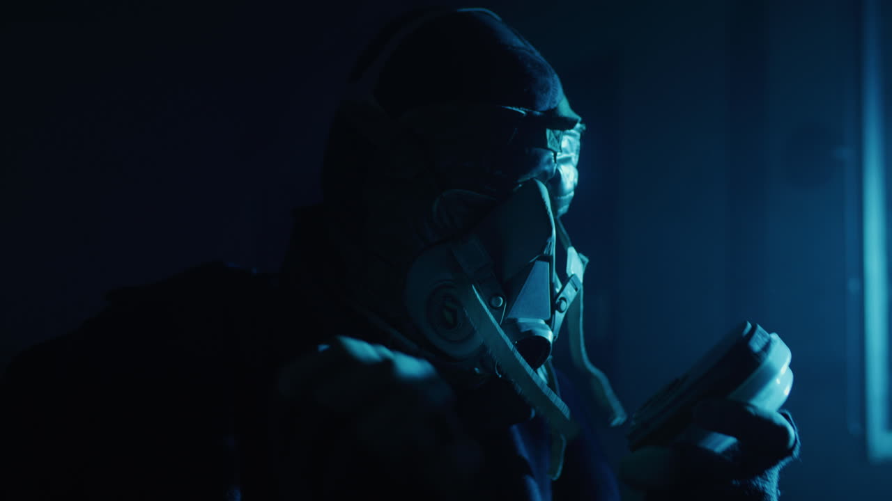 Persona con maschera antigas sotto luce blu