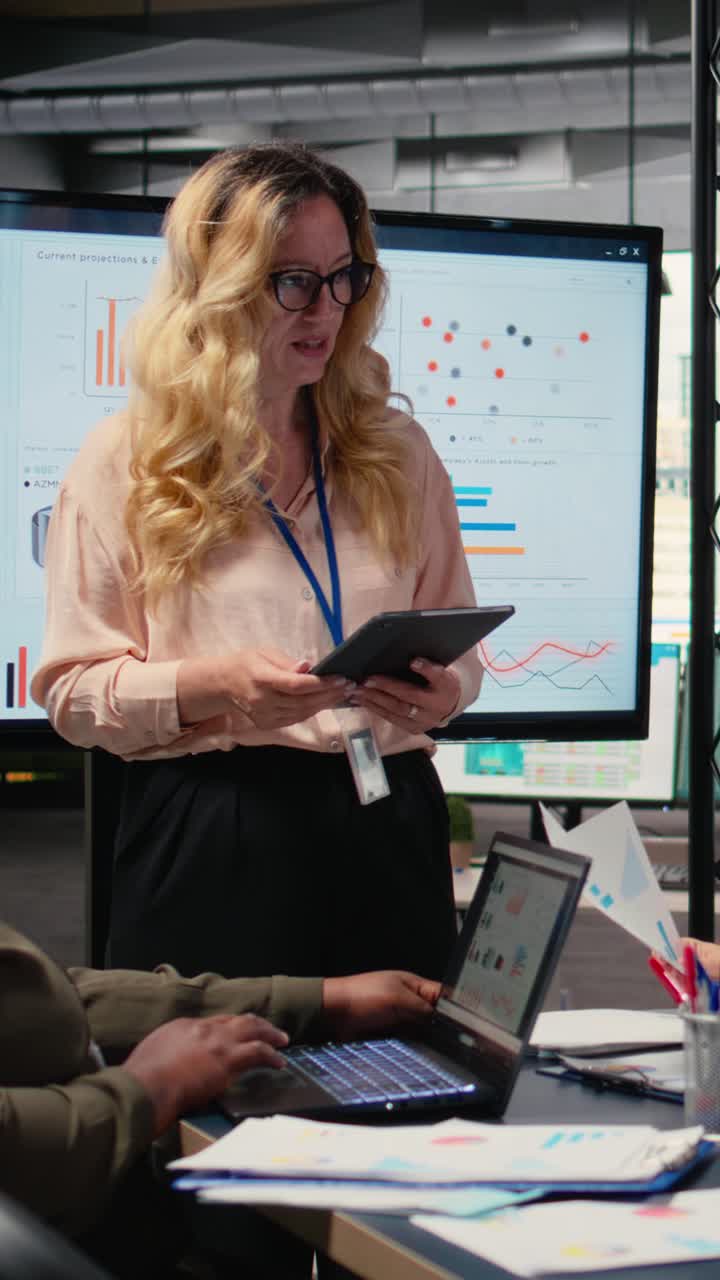 Vertical Video Ambitious CEO presenting performance indicators to her staff in a boardroom