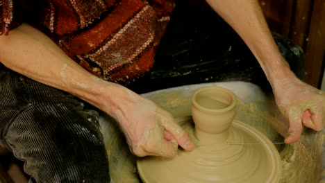 professional male potter working in workshop, studio