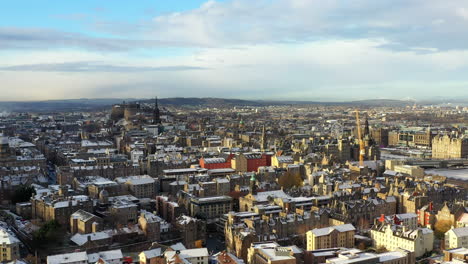 Aerial-shot-of-Edinburgh-castle-and-skyline-covered-in-snow-on-a-crisp-sunny-winters-day