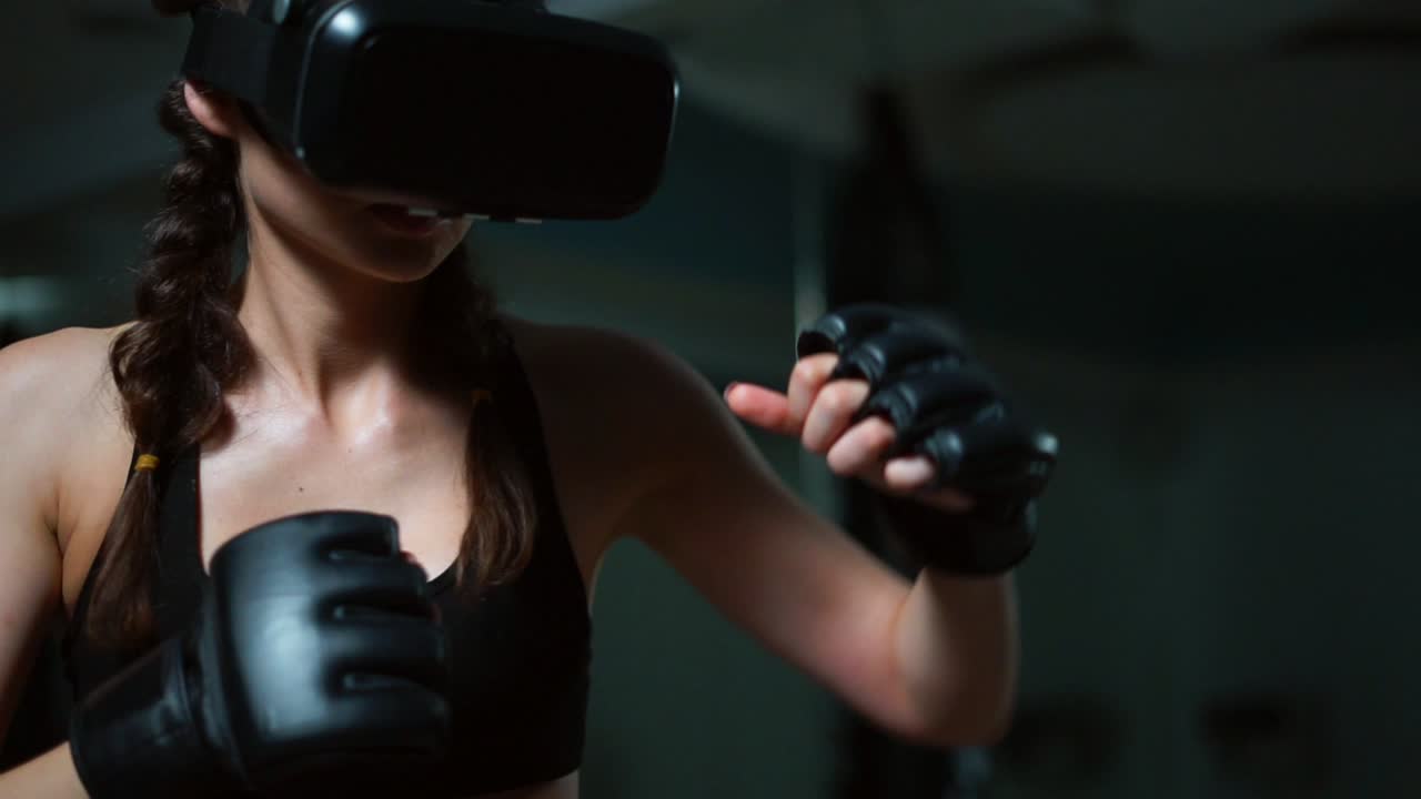 Young attractive woman boxing in VR 360 headset training for kicking in virtual reality. Slow Motion shot