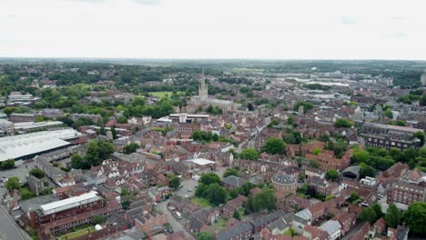 aerial footage over norwich city centre. the footage moves to the left and pans up slowly. shows the cities cathedral, commercial buildings, surrounding residential homes and green areas. norfolk.