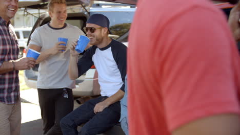 slow motion shot of sports fans tailgating in parking lot