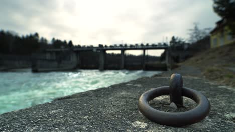 Water-running-under-a-bridge-with-a-with-a-tie-on-the-cement-siding