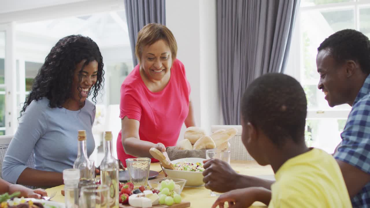Happy african american family eating lunch together at home