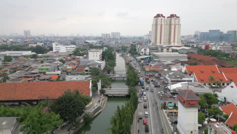 El-Tráfico-Ligero-Viaja-A-Lo-Largo-Del-Canal-Krukut-En-El-Norte-De-Yakarta,-Indonesia,-Retrocediendo