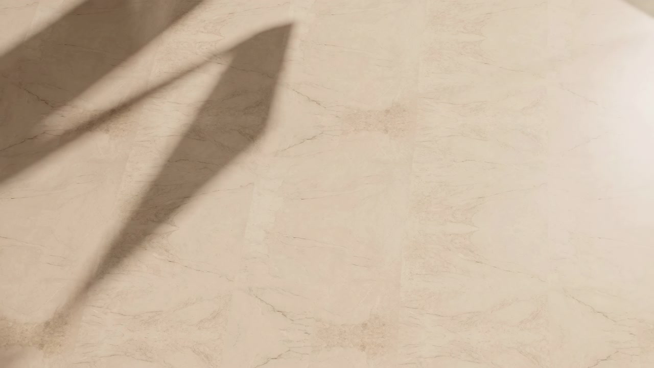 Ombre angolari dai bordi morbidi si estendono su una superficie di marmo beige chiaro, rivelando calde tonalità neutre, sottili venature, contrasto diagonale e motivi di luce stratificati che suggeriscono un movimento silenzioso e un'eleganza raffinata.