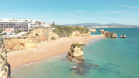 Establishing-shot-of-Dona-Ana-Beach-in-Lagos-Coastline,-Algarve,-Portugal---Aerial-Fly-over-Push-in-wide-shot