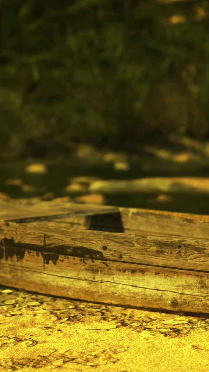 Wooden boat resting on the shore of a tranquil river during sunset