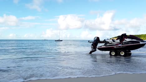 three men pulling jet ski out of blue ocean with aid of waves