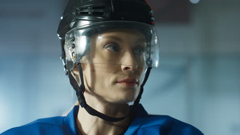 close up of a happy female hockey player looking cheerfully at the camera and breathing in cold air on the ice arena