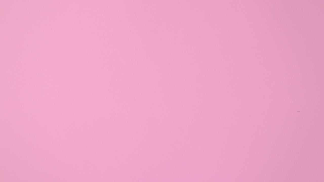 Easter eggs pastel colored appear on white fur on bright pink background. Stop motion