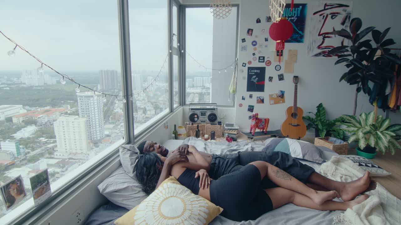 Young Couple Lying in Bed, Hugging and Talking