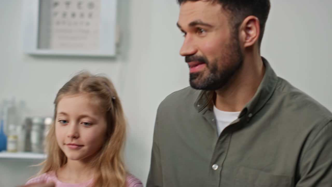 Girl having temperature checked in clinic closeup. Smiling child give high five