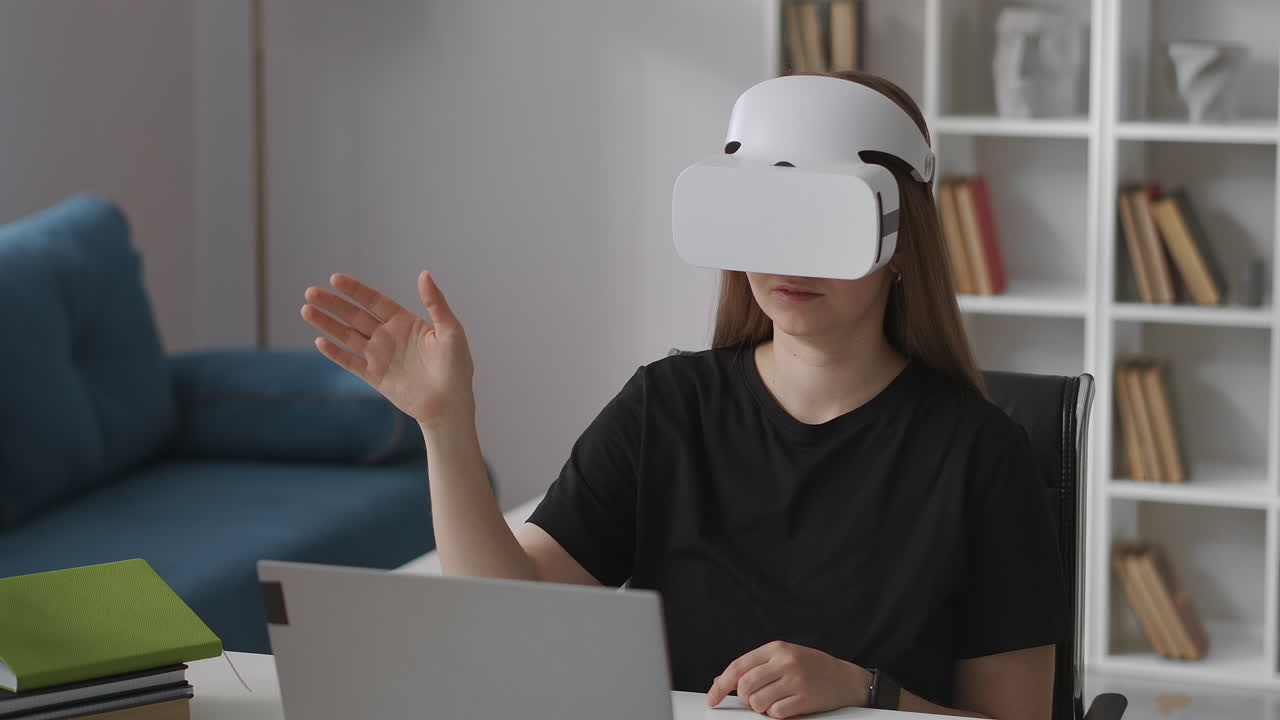 woman is wearing head-mounted display for viewing virtual reality sitting at home gesticulating by hand swiping screen