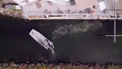 aerial top down view of a motorboat rotating in a tight cannal