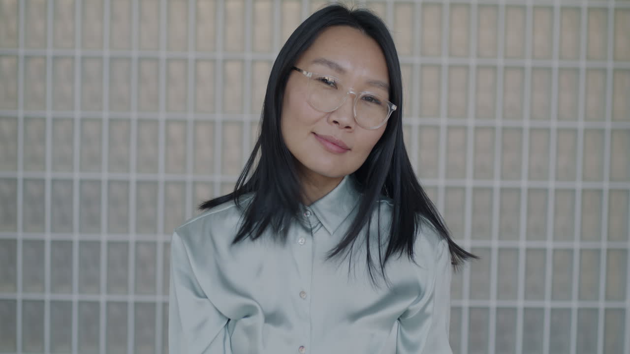 Woman Adjusting Glasses in Modern Office