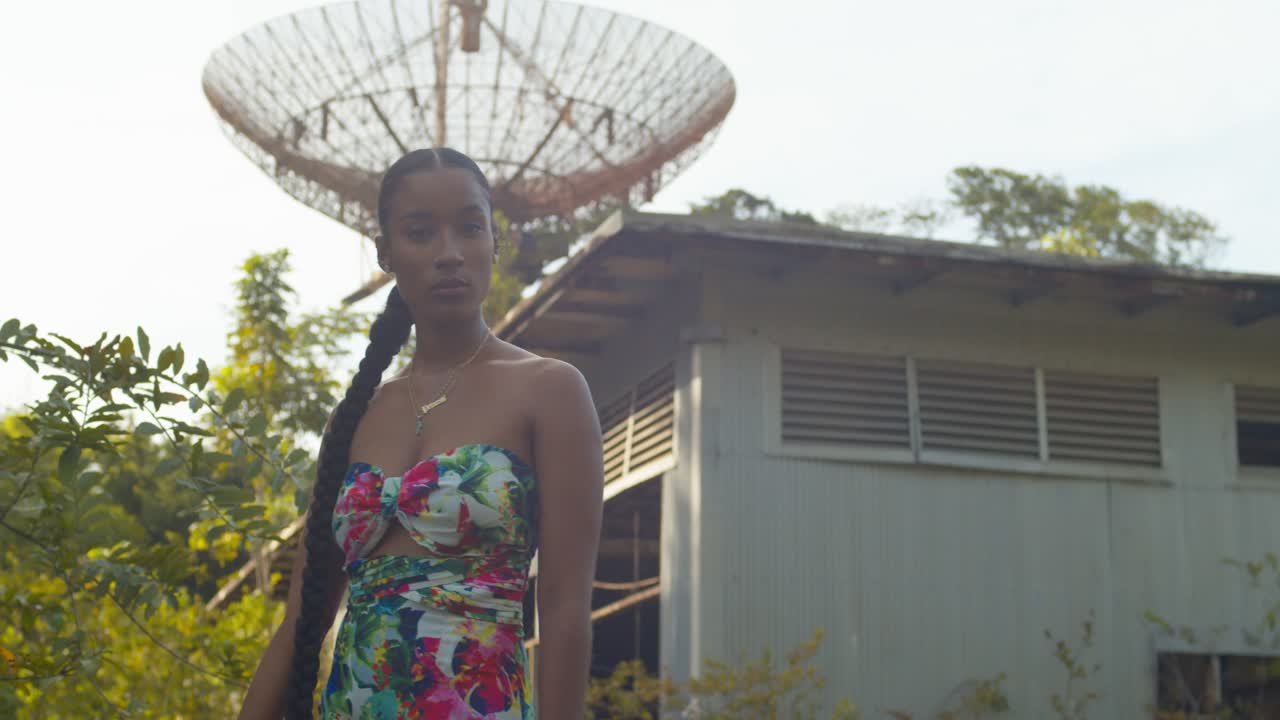 En model går i forgrunden med et forladt radiospore-tårn i baggrunden på øen Trinidad
