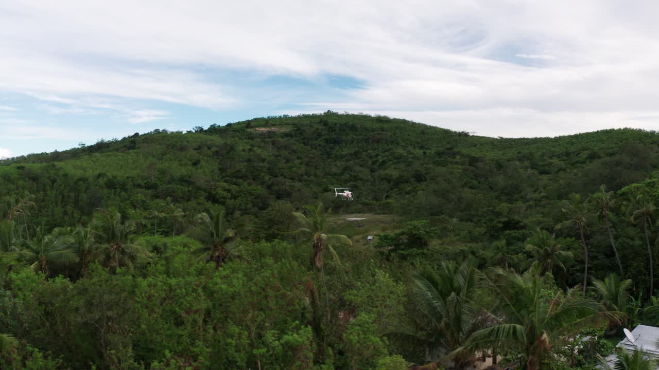 helicóptero sobrevuela el helipuerto en una remota isla tropical en fiji, toma aérea