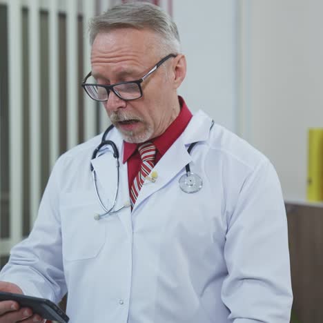 professional doctor using mobile phone for medical consultation. senior doctor learning to work on a phone in medical center. remote work during pandemic.