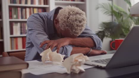 tired african american man rested head on table due to overwork