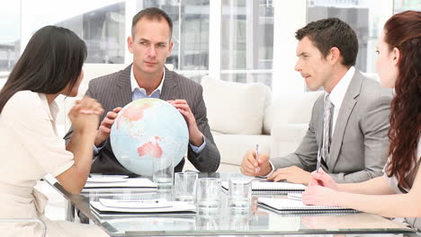 manager holding a terrestrial globe in a meeting