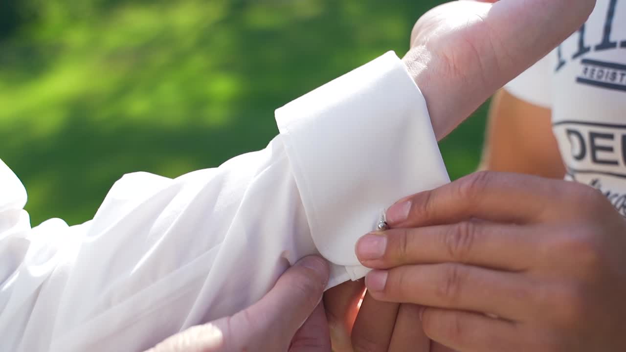 Helping Hand Putting On Cufflinks On White Shirt Off Groom. Follow Shot, Close Up