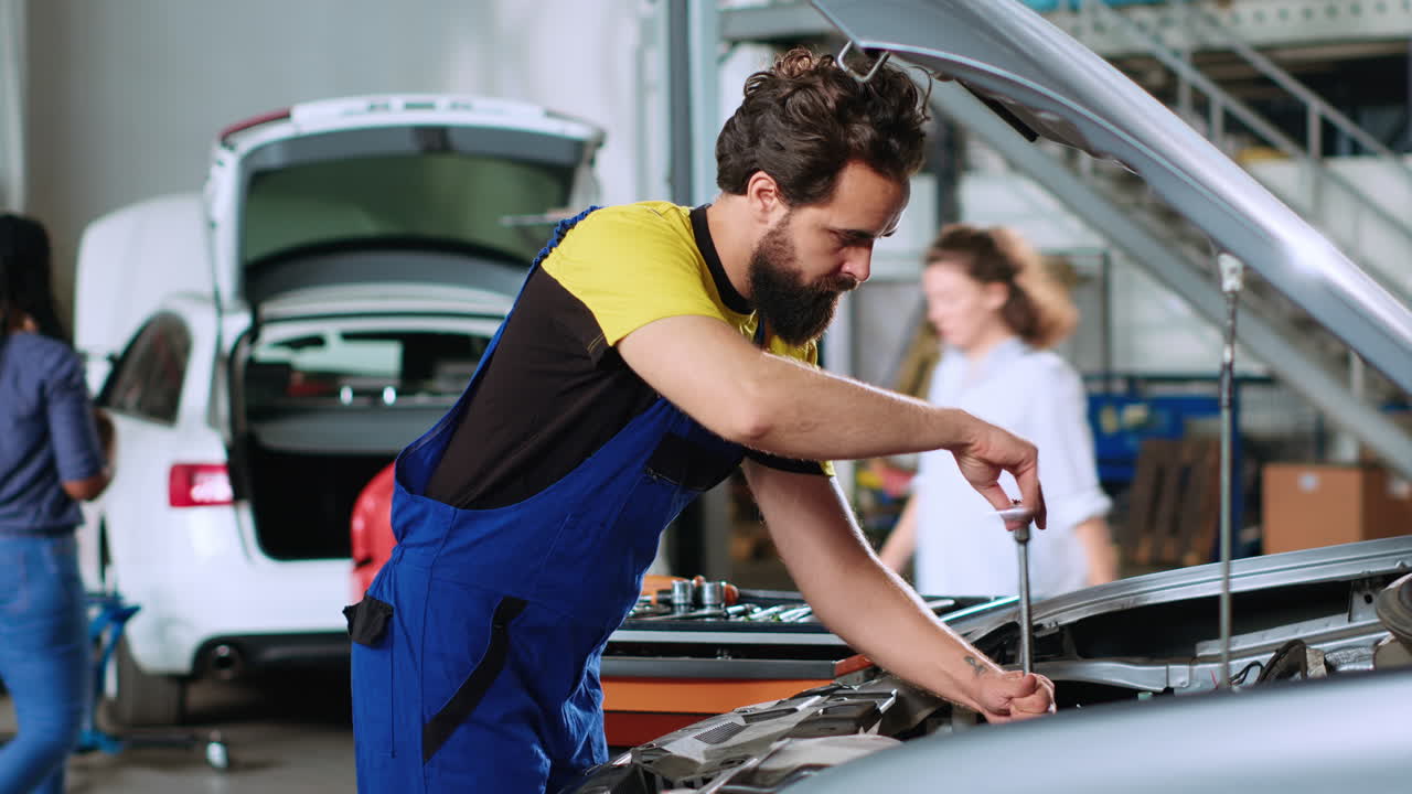 el mecánico en el servicio de automóviles usa llave inglesa