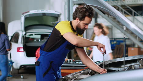 el mecánico en el servicio de automóviles usa llave inglesa