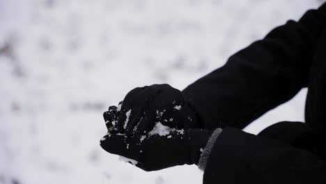 Woman-Gets-Handful-Of-Snow-And-Makes-A-Snowball,-Camera-Close-Up