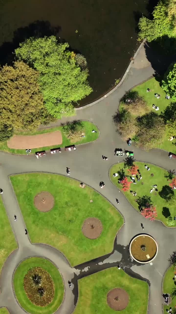 Advancing overhead social ratio aerial video of the grounds of St Stephen's Green in Dublin City Centre, Ireland on a bright and sunny day. Filmed in 1080x1920 and with Rec709 color