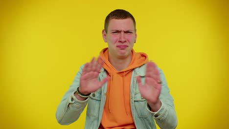 young man making a stop gesture and looking disgusted