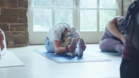 Yoga class with women stretching on yoga mats