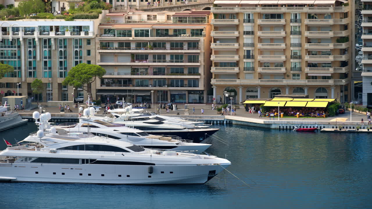 View of boats docked in the Monaco Marina with the skyline of the city on the background