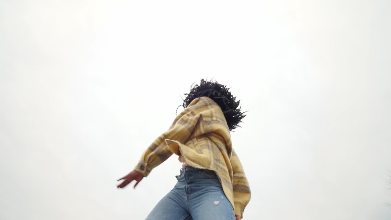 Energetic black woman dancing on concrete border