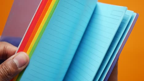 person holding a colorful notebook