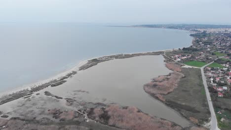 Aerial-Drone-shot-wetland-near-sea-beach-next-to-city-village