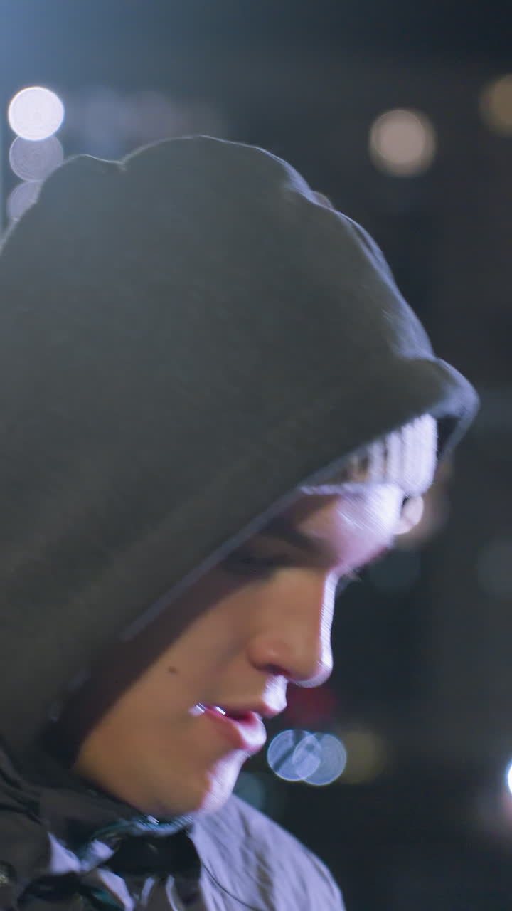 primer plano del entrenamiento del entrenador por la noche mientras hace malabarismos con el fútbol, iluminado por luces de la calle, con efecto de luz bokeh y edificios residenciales en el fondo