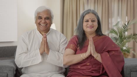 happy old indian couple doing namaste