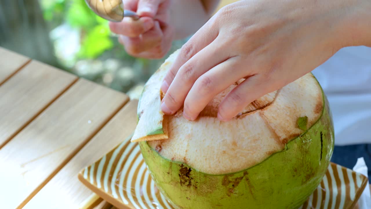 manos hábilmente abrir coco con una cuchara