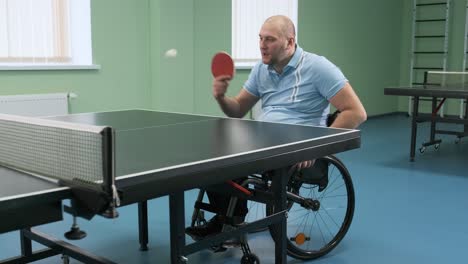 disabled man playing table tennis in wheelchair