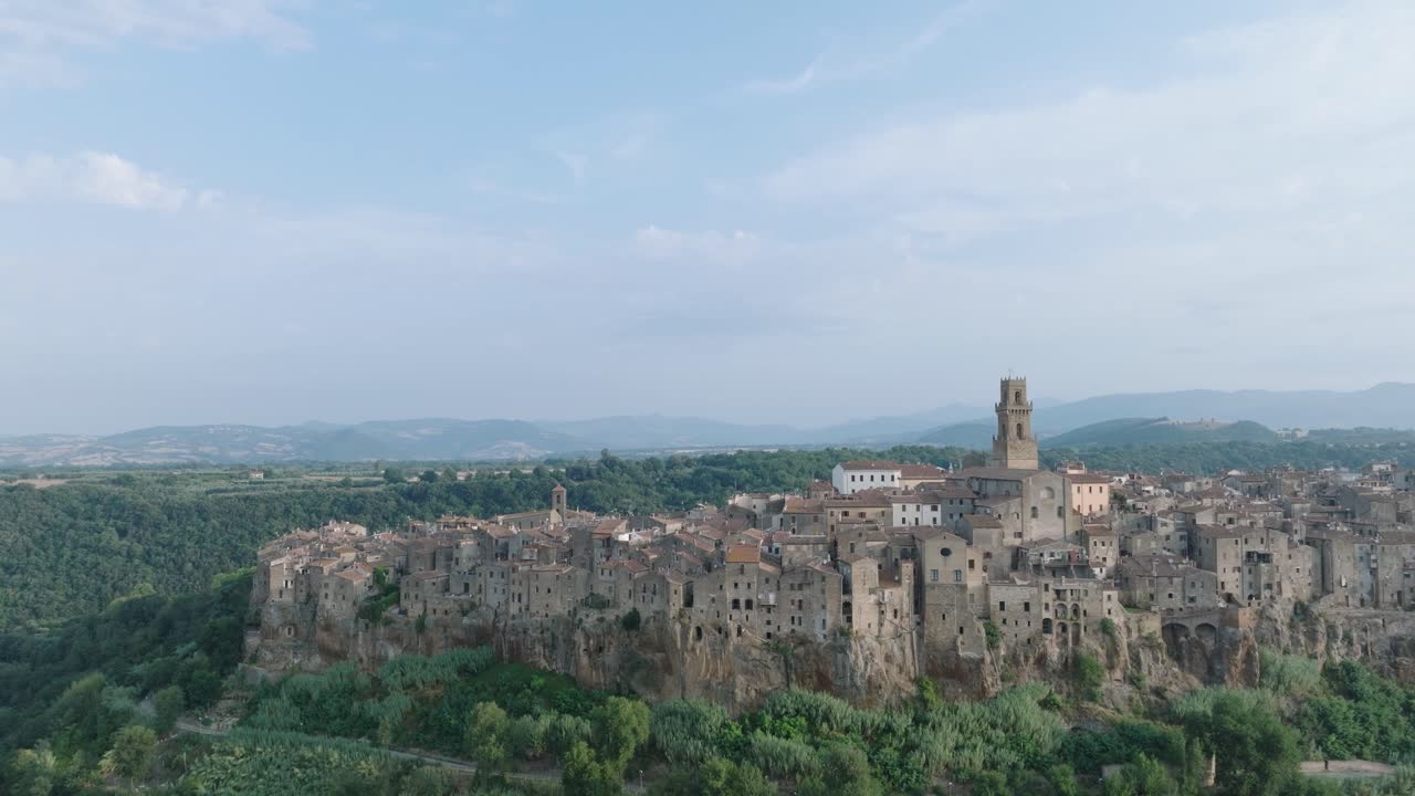 Far Away Aerial Drone view of the hilltop Medieval town of Pitigliano, Tuscany in morning light, with the Valdorcia and old buildings, in 4K