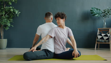 couple practicing back twist yoga pose