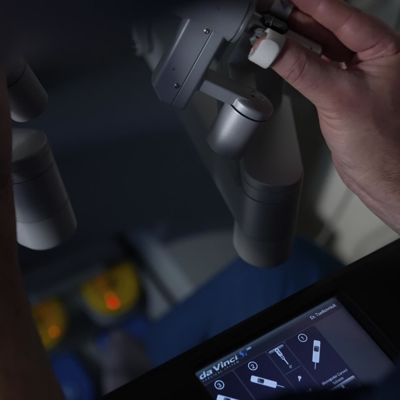 Precise moves of a surgeon operating the innovative surgical equipment. Little sensor screen working in the darkness. Close up