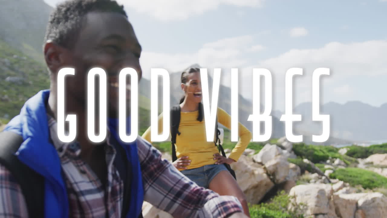 animación de las palabras buenas vibraciones escritas en blanco sobre una pareja caminando en las montañas tomando un descanso
